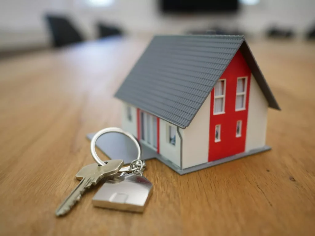 An Image Of A Home Sculpture On A Table With A Key Beside It | Residential Home Construction Loan Calculator | Freshwater Financial Services