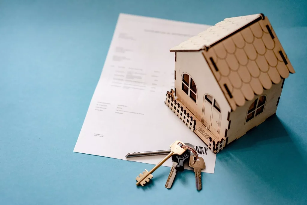 a bird view of a mini house on a table placed above an agreement and besides a bunch of keys | Fixed vs Variable Rates | Freshwater Financial Services